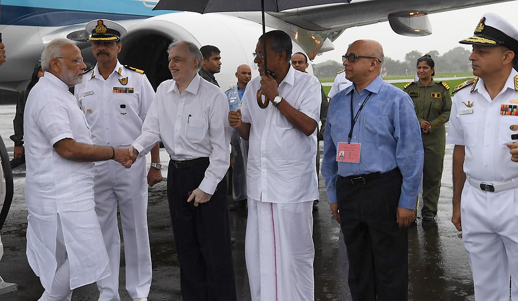 India's Prime Minister Narendra Modi being received by the Governor of Kerala P. Sathasivam and the Chief Minister of Kerala, Pinarayi Vijayan, on his arrival, in Kochi, to survey the flood-affected areas, on 18 August 2018.